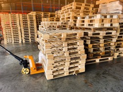 Worker driving forklift to loading and unloading wooden pallets from truck to warehouse cargo storage, shipment in logistics and transportation industrial, wood pallets stack