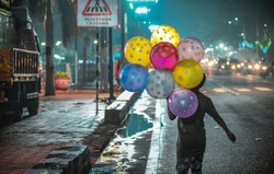 A poor child selling beautiful and colorful balloons on the street of Hyderabad to earn his living.
