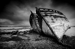FINE ART OLD DERELICT WOODEN BOATS  ON BEACH  MOODY BLACK AND WHITE  SALEN ISLE OF MULL SCOTLAND 