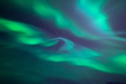 Stunning aurora borealis. Shape of fast moving lights of crown aurora. Looking directly up in the sky. Northern ligths, green purple and blue colors.
