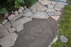 flagstone, sandstone landscaping in a country house, drainage systems and the arrangement of paths in front of the house with a lawn