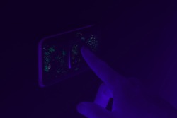 Black UV light exposing germs and bacteria on hand touching lighting switch - Ultraviolet blacklight shows hidden harmful infectious disease - Corona virus, hygiene, sickness and covid-19 concept