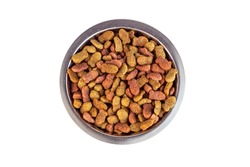 Top view of brown kibble pieces for cat feed in a metal bowl isolated on white background. Healthy dry pet food