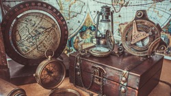 Old antique rare items collections including with a compass, oil lamp, globe model rotation on a wooden base and treasure chest of pirate and sailing on the ocean. (vintage style) 