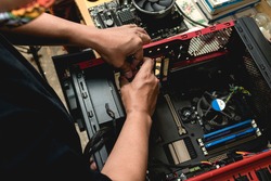 A computer technician assembles a desktop computer with new parts. Upgrading or replacing PC parts.