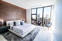 Modern and luxurious bedroom with white ceiling and wood accents with views of Tokyo skyline, particularly Minato ward. Condo or Hotel accomodation.