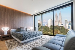 Modern and contemporary bedroom with white ceiling and wood accents with views of Kuala Lumpur skyline. Condo or Hotel accommodation.