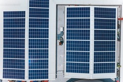 Top view of an array of polycrystalline solar panels installed on the roof of a shopping mall.