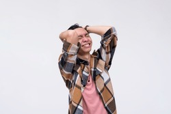 A young frustrated asian man venting out and breaking down from stress. Screwing up and overwhelmed by pressure. Mental health concept. Isolated on a white background.