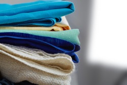 Home interior, tailor, sewing, diy concept. Heap of colorful cloth fabrics. Color Wool, cotton linen clothes. Closeup. 
