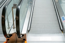 View of an empty escalator without people in a public shopping center. Moving stairs and escalator railings of a major airport or subway. Interior of corridors and central hall of a mall. 