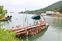 Colorful old fishing boats sunk in the sea with blue sky background at Chanthaburi province ,Thailand