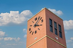 Orange clock tower building, bright blue sky background Leave the active copy area