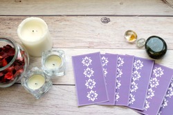 Deck of tarot spreads on white wooden table near candles and gemstones.Fortune teller reading and forecasting concept.
