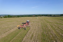 Rowing the mown grass with a tractor. Preparation of fodder for cattle for the winter. Top view.