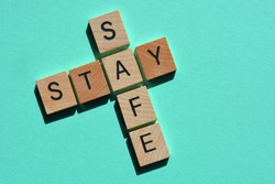 Stay Safe, words in 3d wood alphabet letters in crossword form isolated on blue background