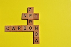 Net, Zero, Carbon, Now, words in wooden alphabet letters in crossword form isolated on yellow background with copy space