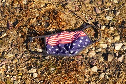 American freedom face mask laying on the ground showing disgrace. 