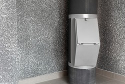 Waste disposal container installed on the floor of a multi-storey building on the grey background. Cleaning and maintenance concept trash and linen and chute systems. Copy space.