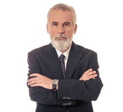 Handsome bearded mature businessman in classic suit is looking at camera while standing with crossed arms on a white background