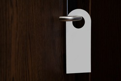 Door knob with blank doorhanger mock up. Empty white flyer mockup hang on door handle. Leaflet design. Dont disturb sign. Hotel room clear hanger. Do not disturbing signal.