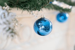 Blue Christmas ball hanging from a Christmas tree branch