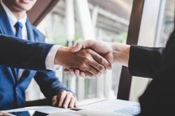 Finishing up a meeting, handshake of two happy business people after contract agreement to become a partner, collaborative teamwork.