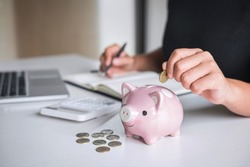 Woman putting golden coin in pink piggy bank for step up growing business to profit and saving with piggy bank, Saving money for future plan and retirement fund concept.