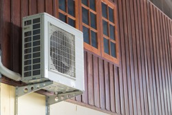 Air conditioning units installed outside the house on wooden wall