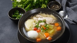 South American Caldo de Gallina chicken noodle soup with boiled egg and herbs. The classic Peruvian chicken noodle soup. 