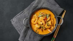 Thai shrimps red curry. Thailand tradition red curry soup with shrimps prawns and coconut milk. Panaeng Curry and dark background.
