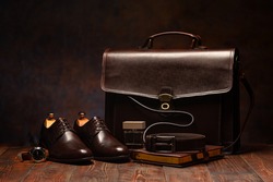 Still life shot of business men's briefcase, leather shoes, diary and watch