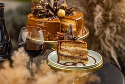 Chocolate layer cake with fancy chocolate decoration served with a glass of wine
