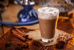 Hot chai latte with spices like cinnamon, cardamon, cloves, star anise as a sweet warm winter dessert drink