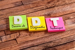 Colorful square papers with wooden white letters for the french acronym DDT means Technical Diagnostic Folder