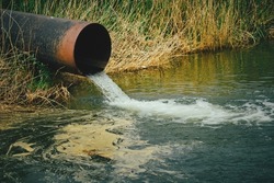 Draining sewage from pipe into river, pollution rivers and ecology
