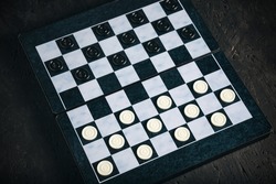 Checkers board with chips black background, checkers logical board game