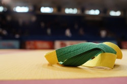 BJJ brazilian Jiujitsu competition green and yellow belt on the tatami mats at the tournament