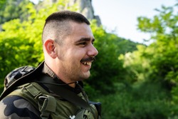 Special force military soldier portrait smiling in battle zone or military practice wearing combat uniform