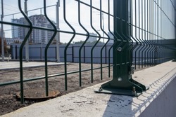 Steel lattice green fence with wire. Fencing. Grid industrial wire fence panels, pvc metal. Installation of sectional fencing. Welded mesh fence. Installation of a grid for fencing the territory