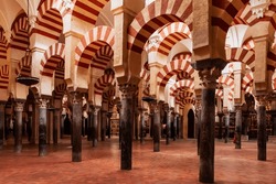 Striped arches and pillars in the prayer room inside the cathedral mosque of Cordoba.