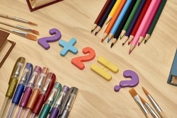 arithmetic example 2 plus 2 equals a question mark on the table around the book pencils fountain pens the concept of education school. High quality photo