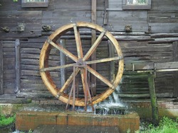 Old wooden wheel from a mill on the river