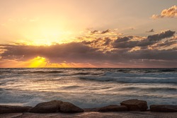 seascape sunset with cloudy sky and high surf golden hour