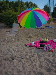 Image of beach umbrella in the colors of the lgbt flag on the beach near Lake Bracciano