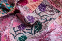 Pretty pinks and purple Indian patchwork quilt with hand stitched flowers, glittery threads and the traditional Kantha running stitch embroidered by hand running from top to bottom
