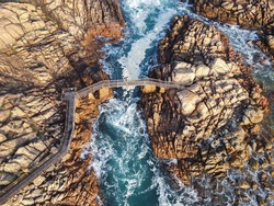 Aerial photograph of the rough sea pushing under the bridge at Canal Rocks. Canal Rocks, Yallingup - Western Australia
