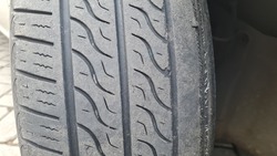 old black tire treads that are broken and worn. time to change tires. Tire tread problem and solution concept.