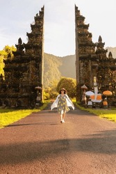 tourists walking happily vacationing in bali. Amazing view of Handara gate in the morning with the mist over mountains in Bali, Indonesia.