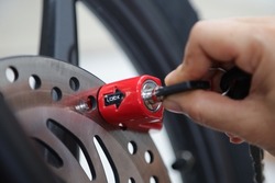 lock the disc brake disc with a safety lock or padlock to anticipate motorcycle theft.  anti theft lock concept